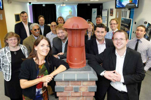 Henriette Lyttle of Bham Sci Park & Cllr James McKay with Ventives low-carbon chimney innovation (low carbon entreps in back)