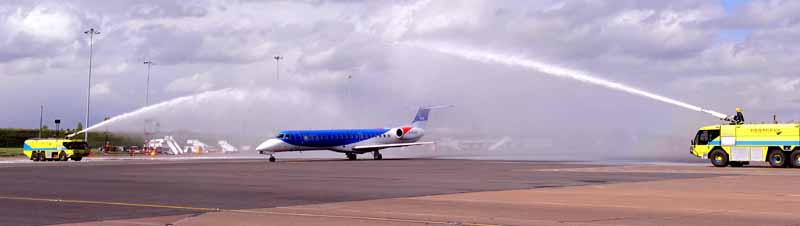 bmi regional aircraft departs from Birmingham Airport under celebratory water arch. 